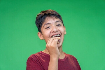 teenager eating cookies on a green background