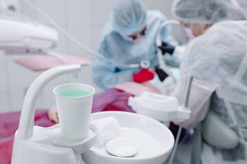 Vertical shot of mouth rinse tap at dental office, dentist working on background