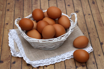 Ein Korb mit Eiern auf einem Holzhintergrund.