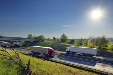 Landscape with a moving truck on the highway at sunset