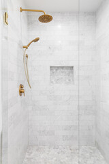A luxury shower with a gold faucet and shower head, marble subway tile walls, and marble hexagon tile shelf and floor. - obrazy, fototapety, plakaty