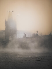 sunrise over the Charles bridge with mist in Prague