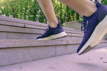 Man athlete legs running up stairs training intense cardio work out exercise, male runner feet jogging in city park