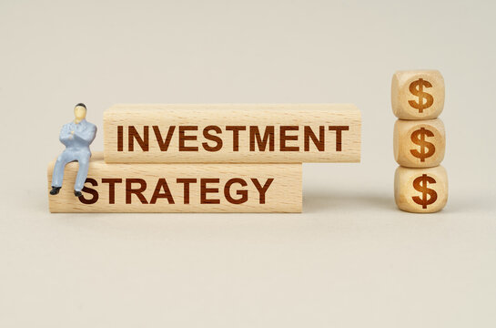 On the blocks with the inscription - Investment Strategy, the figure of a businessman sits, next to the cubes