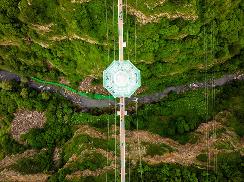 Dashbashi, Georgia - 19th june, 2022: Aerial circle over Diamond cafe on glass bridge over scenic dashbashi valley in Georgia countryside. Famous modern bridge over valley