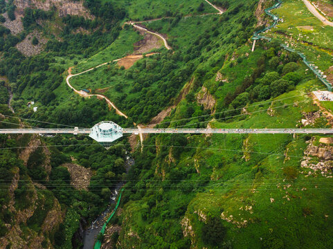 Dashbashi, Georgia - 19th june, 2022: Aerial fly over Diamond shape platform on glass bridge over scenic dashbashi valley in Georgia countryside. Famous modern bridge over valley in caucasus