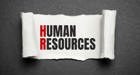 Torn grey paper on white surface with HUMAN RESOURCES word. Business concept