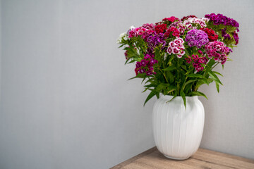 a bouquet of flowers in a vase on the table. the concept of spring. home decoration, interior. 