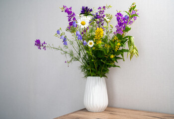 a bouquet of flowers in a vase on the table. the concept of spring. home decoration, interior. 