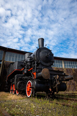 Fototapeta na wymiar A steam locomotive standing outside of historic locomotive shed. The shot was taken in natural lighting conditions