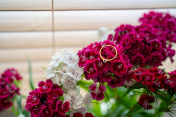 gold ring on top of the flower bouquet. Wedding gift, proposal.