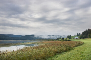 Fototapeta na wymiar lac de Remoray dans le Doubs en Franche Comté à l'aube avec une brume automnale