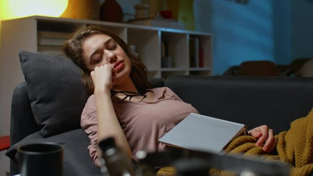 woman napping at home. she fell asleep while reading book	