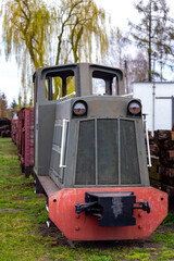 An old, narrow track diesel locomotive standing at the museum's train station. Picture taken on a cloudy day, soft natural light.