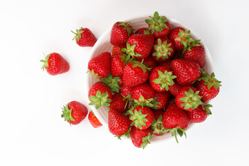 Red ripe strawberry in the white bowl, glossy background