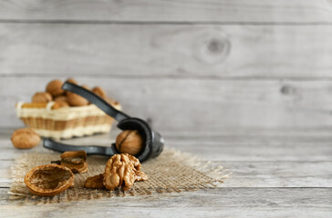 Walnuts are split on a wooden table, copy space. They contain B vitamins, vitamin C, vitamin PP, vitamin A, vitamin E; minerals sodium, potassium, iron, magnesium, iodine, zinc, cobalt