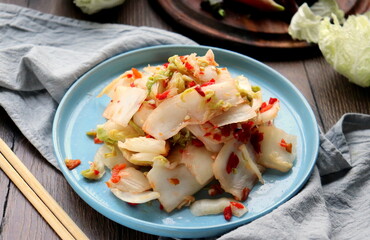 pickled Peking cabbage and hot pepper salad close-up on a blue plate selective focus.