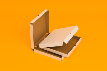 two pizza boxes open on yellow background