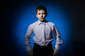 pupil boy in a white shirt on a dark background