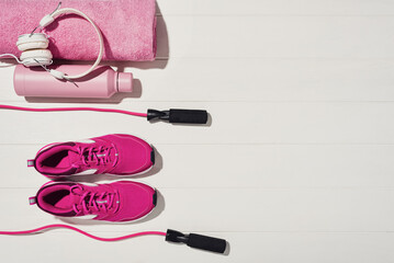 Fitness or bodybuilding concept on white wooden flooor background. Sport equipment for training at home. Photograph taken from above, top view with lots of copy space