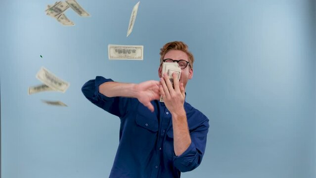 Funny man scatters money isolated on a blue background