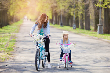mother and child riding bikes in park