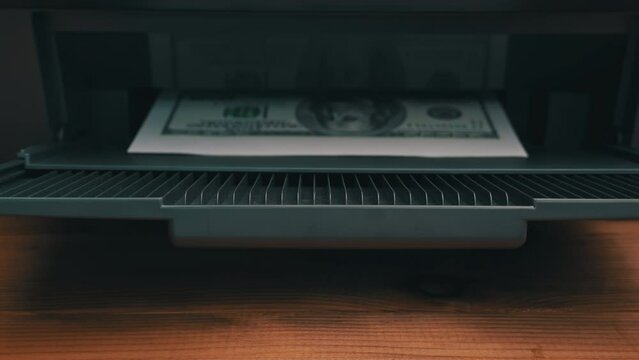 Print on a counterfeit one hundred dollar bill. Fake money, illegal actions. Illegal printing of money. American dollars print on A4 sheet.