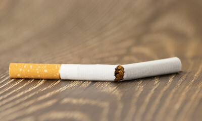 Broken cigar close up view on wooden background
