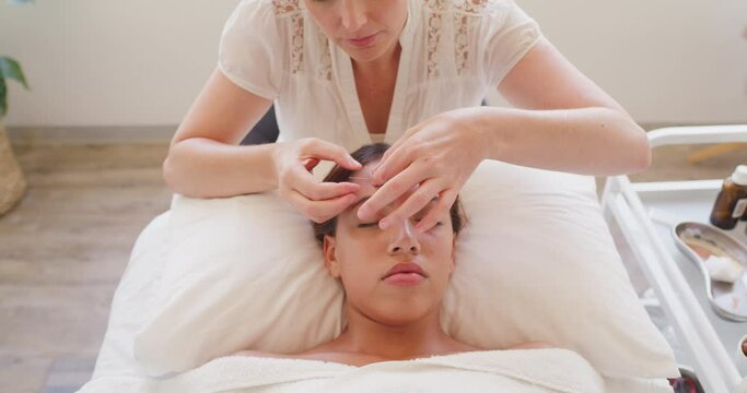 Professional acupuncturist treating patient with needles.Therapist using acupuncture needles in latino client face and forehead. Releasing facial muscle tension with holistic gentle treatment