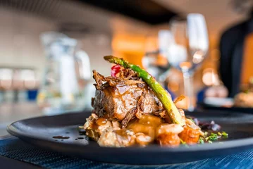 Sierkussen Restaurant Close-Up of healthy gourmet meal served in black plate. Tasty food displayed on dining table at restaurant. Delicious dinner at luxurious resort.  © Aerial Film Studio