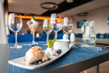 Various confectionery dessert with wineglasses arranged on dining table. Tempting sweet food served in plate with beverages. Concept of fine dining at restaurant in luxurious resort.