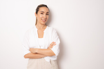 Fototapeta premium Young business woman in white casual shirt standing with arms folded isolated over white background.