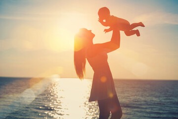 silhouette of a parent and child on the beach at sunset