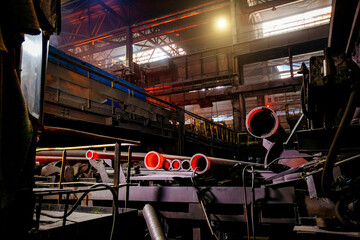 Freshly cast red hot iron pipe at the foundry