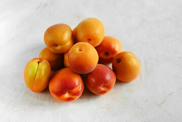 Heap of fresh ripe apricots on a table made of natural marble, copy space. Apricots are rich in vitamins and minerals such as: vitamin A, beta-carotene, vitamin C, potassium, silicon, cobalt