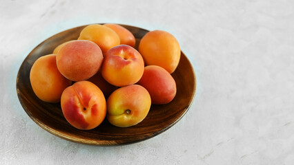 Bowl of fresh ripe apricots  on a wooden table, copy space