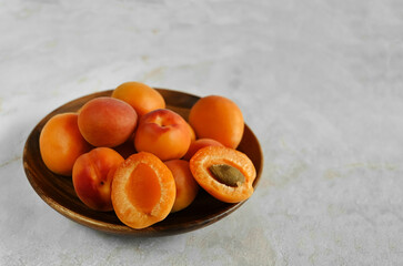 Bowl of fresh ripe apricots on a natural marble table, copy space. Apricots are rich in vitamins and minerals such as: vitamin A, beta-carotene, vitamin C, potassium, silicon, cobalt, manganese