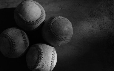Dark moody lighting with selective focus on baseball balls for sports competition background.