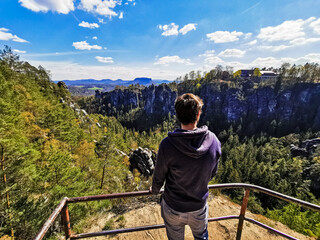 A young man looking at the bastei in saxon switzerland national park, Germany.