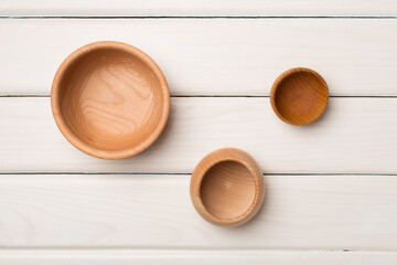 Wooden bowls on wooden background, top view