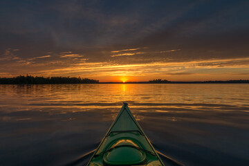 Sunset kayaking on a calm lake in Northwest Ontario, Canada.