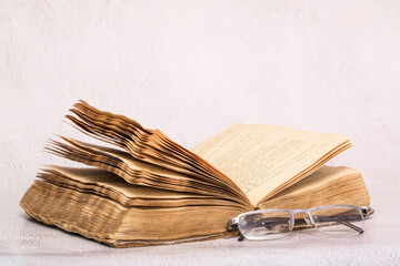 Antique open book on a light table background. Education and science. Knowledge of old Tielerature. Copy space with space for text.