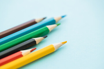 colored pencils row with wave on blue background