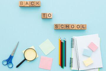 Blank notebook and school supplies. Creative flat lay. Back to school written wooden cubes