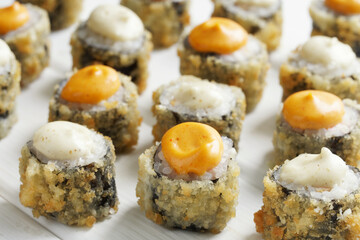 Many appetizing baked tempura rolls on a white background. Macro. Selective focus.