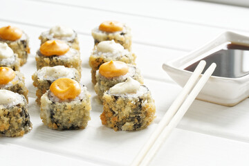 Unusual baked rolls and a Japanese gravy boat - seyuzaru with chopsticks - varibashi and soy sauce. Background from white painted boards. Macro. Selective focus