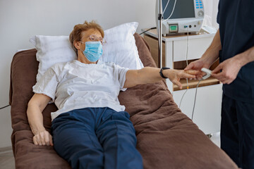 Nurse checking with fingertip pulse oximeter oxygen saturation of patient blood. High quality photo