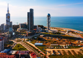 Obraz premium Scenic aerial view of Barumi coastal cityscape overlooking seaside boulevard, sandy beach and modern skyscrapers on sunny spring day, Georgia