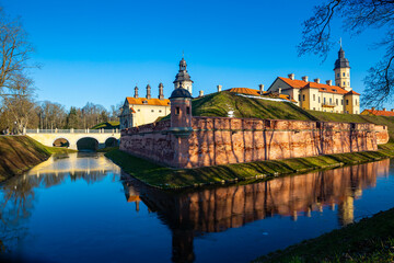 Fototapeta na wymiar Scenic winter landscape with architectural and cultural complex of Nesvizh Castle on sunny day, Minsk region, Belarus