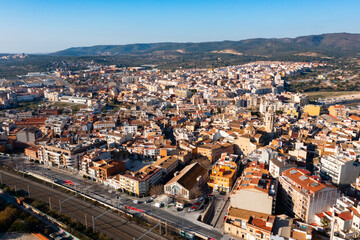 Obraz premium View from drone of El Vendrell cityscape with brownish roofs of residential buildings on sunny winter day, Catalonia, Spain..